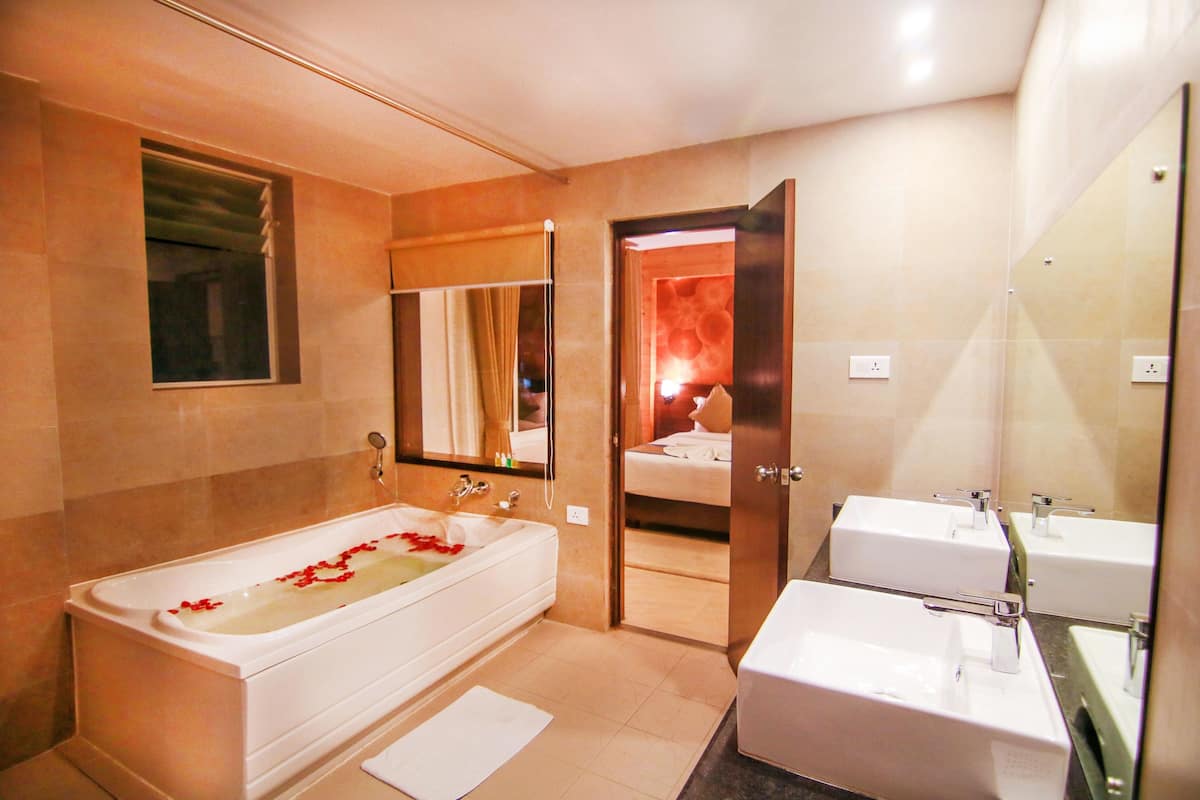 junior suite | bathroom | combined shower/bathtub, deep-soaking bathtub, free toiletries, slippers