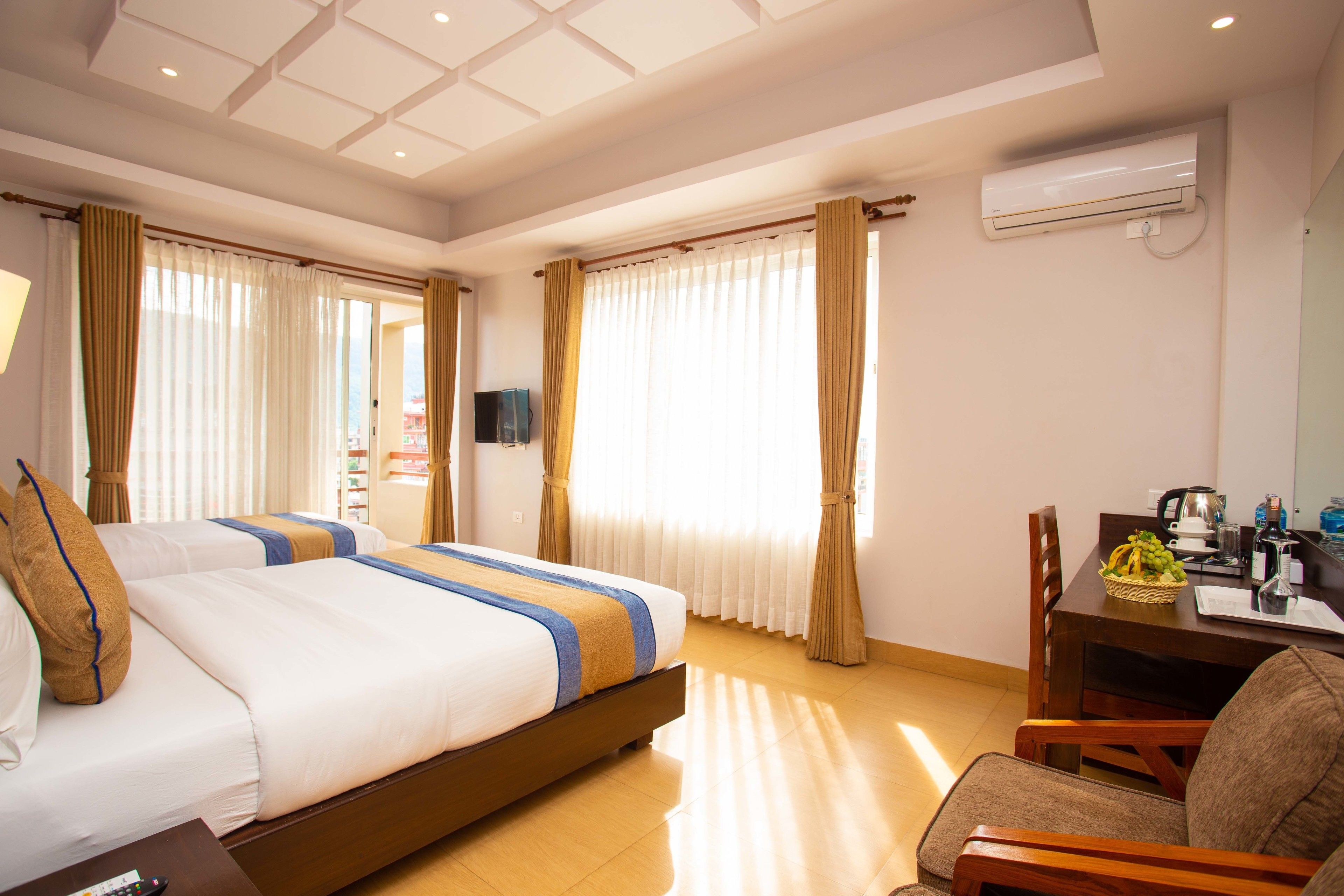 Une chambre d’hôtel avec deux lits, un bureau et une chaise.