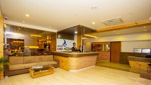 A hotel lobby with a reception desk, a sofa, a coffee table, and a bar area. - Hotel Lake Paradise (Pokhara)
