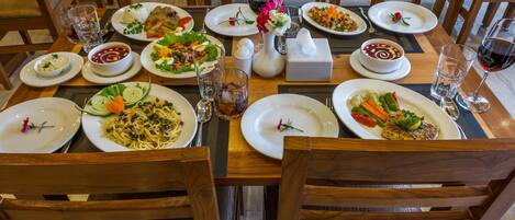 A dining table set with plates of food, glasses, and cutlery.