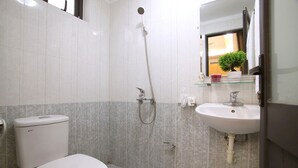 A bathroom with a toilet, a shower, and a sink. - Granda Central Apartment (Hanoi)