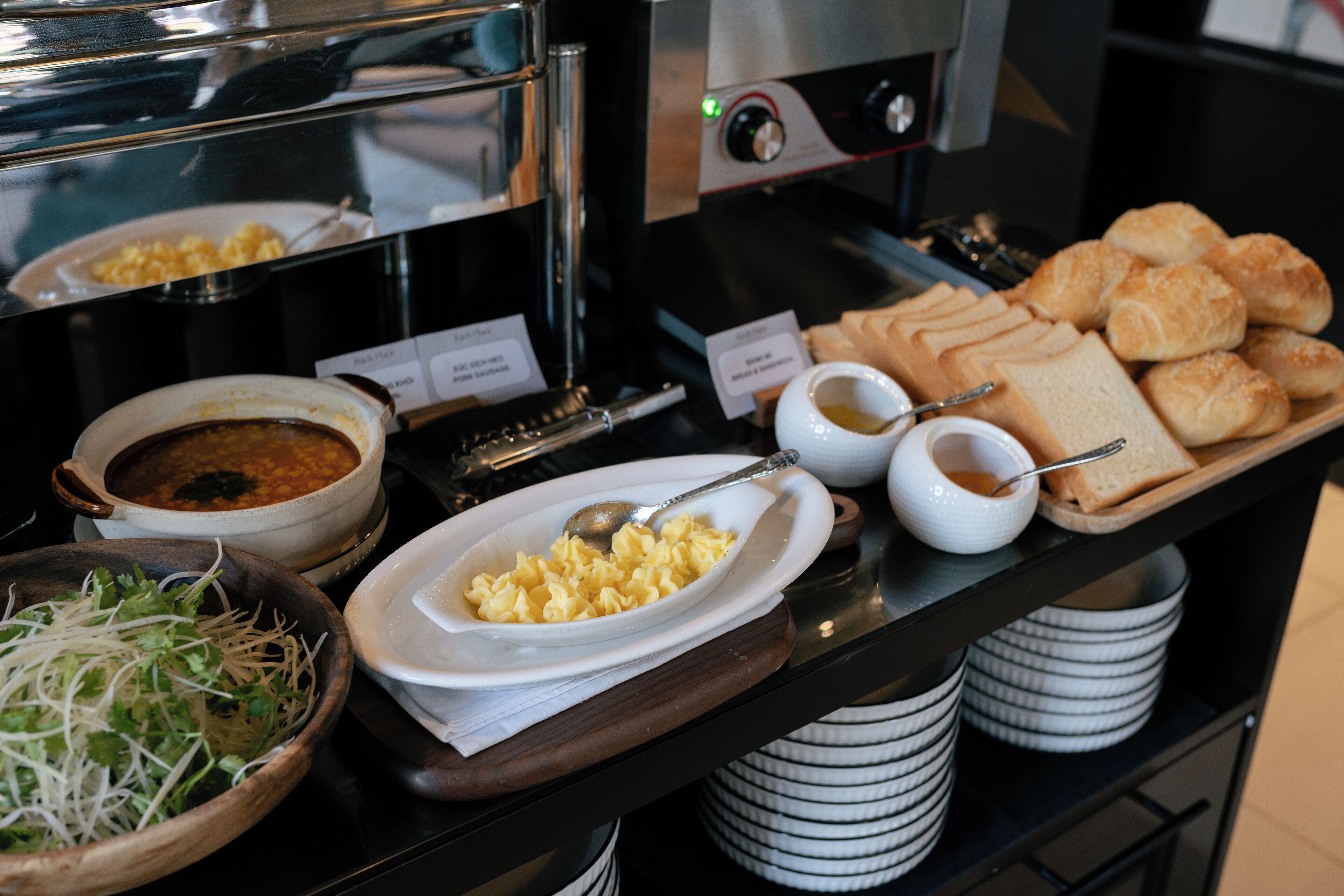 A buffet with various dishes including soup, salad, bread, and pastries.