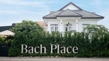 A building with a sign reading "Bach Place" in front.
