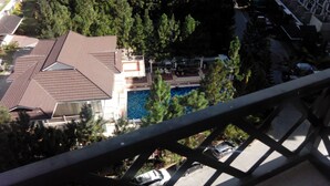 A residential building with a swimming pool, surrounded by trees and a parking area. - Camella Northpoint Condominium by Diamond Star Management Services (Davao)
