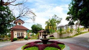A landscaped area with a central fountain, surrounded by a circular brick pathway. - Camella Northpoint Condominium by Diamond Star Management Services (Davao)