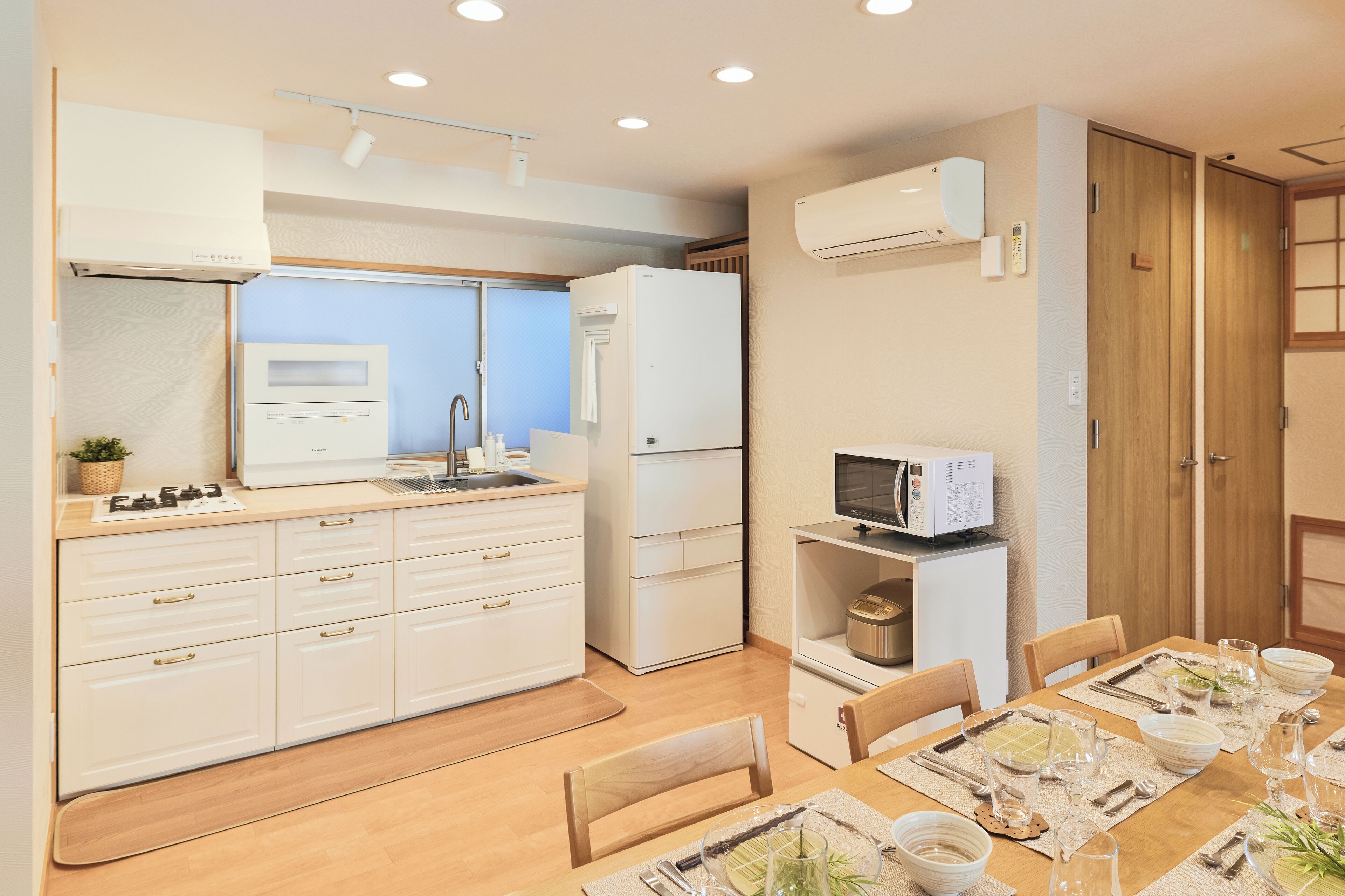 A compact kitchen with white cabinets, a microwave, and a refrigerator.