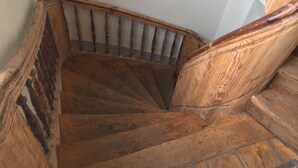 A wooden staircase with a handrail and a curved design. - Heart of Riga Apartment (Riga)