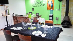 Un espace repas agrémenté d’un mur vert, d’un comptoir en briques et d’une cheminée.