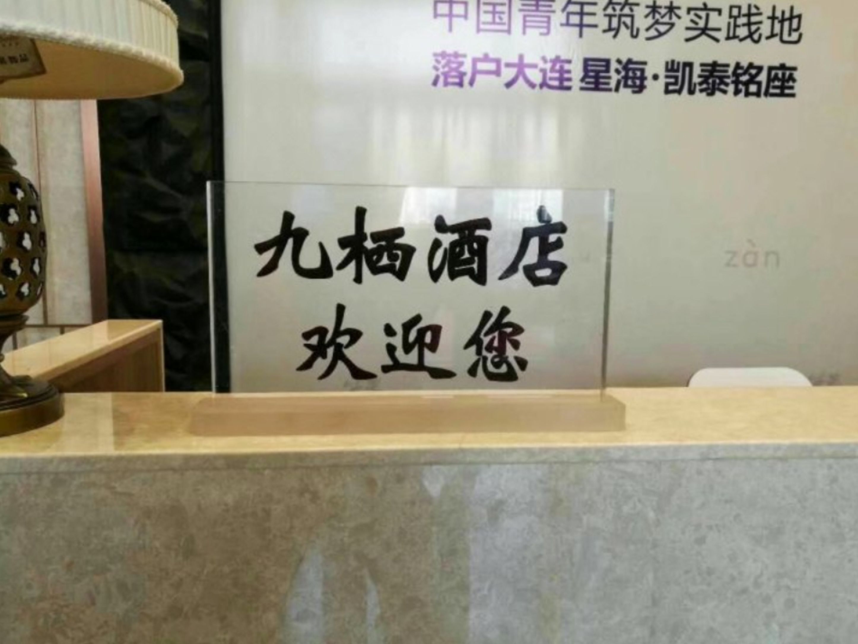 A hotel sign with Chinese characters welcoming guests.