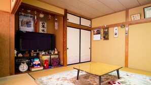 A traditional Japanese room with tatami flooring, a low table, and sliding doors. - Chokiya (Fujikawaguchiko)