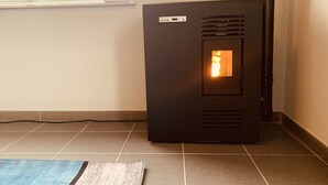 Quarto com piso ladrilhado, aquecedor e janela.