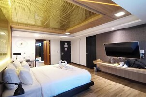Una habitación de hotel moderna con una cama grande, un televisor de pantalla plana y un techo de madera.