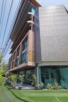 Un edificio moderno con fachada de madera y metal, ventanas amplias y techo plano.