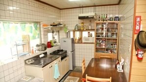Cocina compacta con lavabo, estufa y microondas. Hay una mesa de comedor con sillas y una alfombra pequeña.