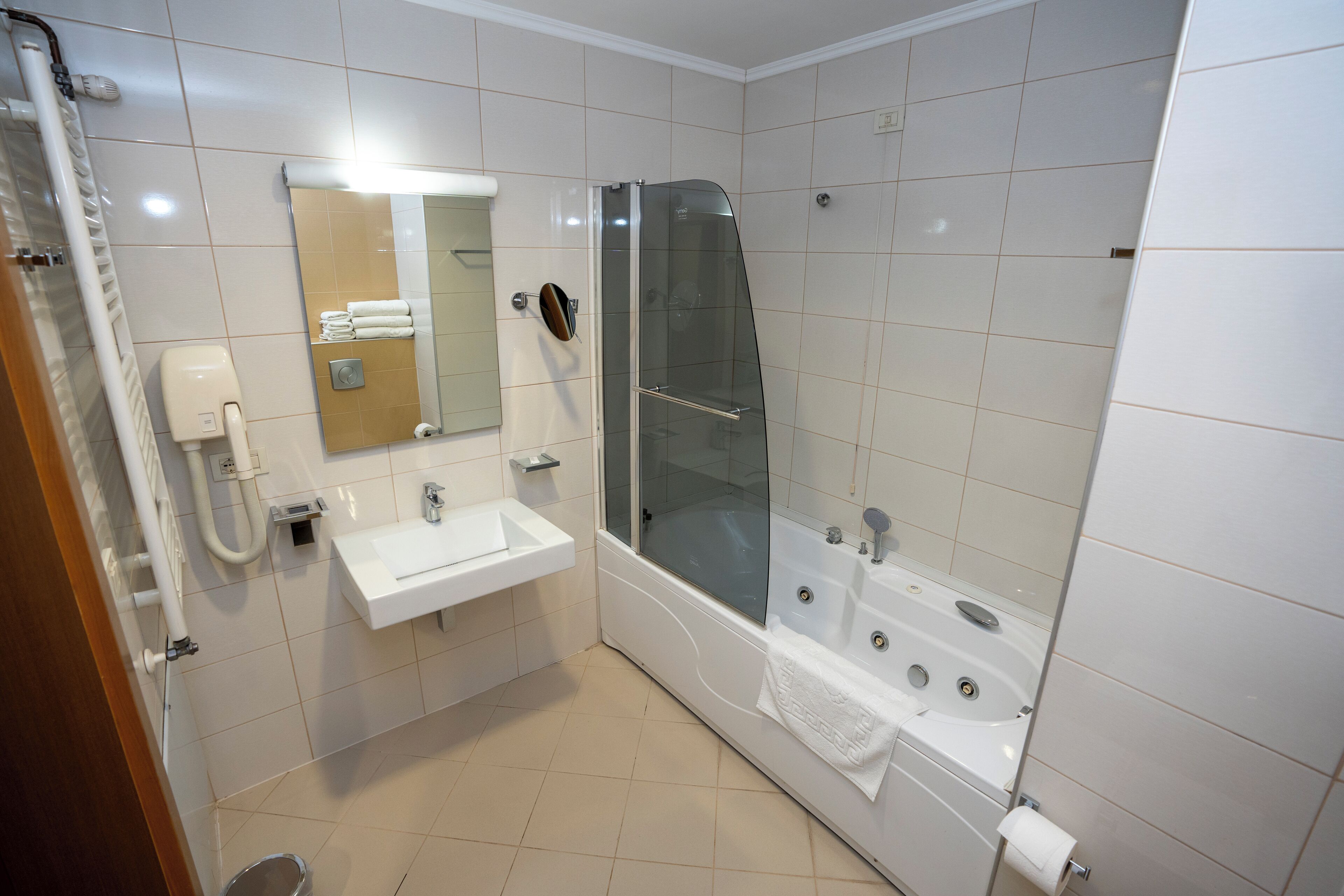 A modern bathroom with a glass-enclosed shower, a sink, and a bathtub.
