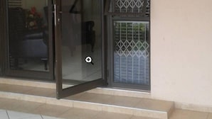 Une porte-fenêtre coulissante donnant sur une pièce avec vue sur un jardin.