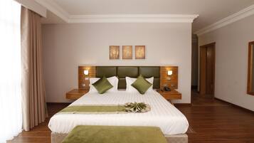 Une chambre spacieuse avec un grand lit, deux tables de chevet et une tête de lit.
