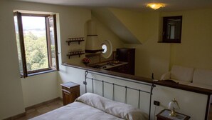 A bedroom with a bed, a window, a small table, and a nightstand. - Milord Relais (Massa Lubrense)