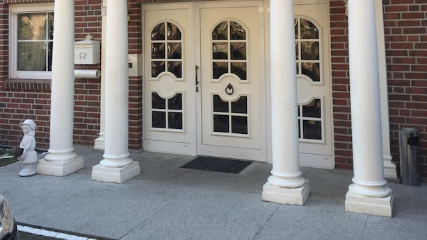 A hotel entrance with a classic facade, featuring a central entrance flanked by columns and a pediment above the doors. - Hotel Marjani (Sarstedt)