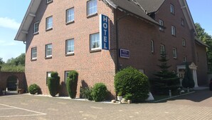 A brick building with a sign indicating it is a hotel. - Hotel Marjani (Sarstedt)