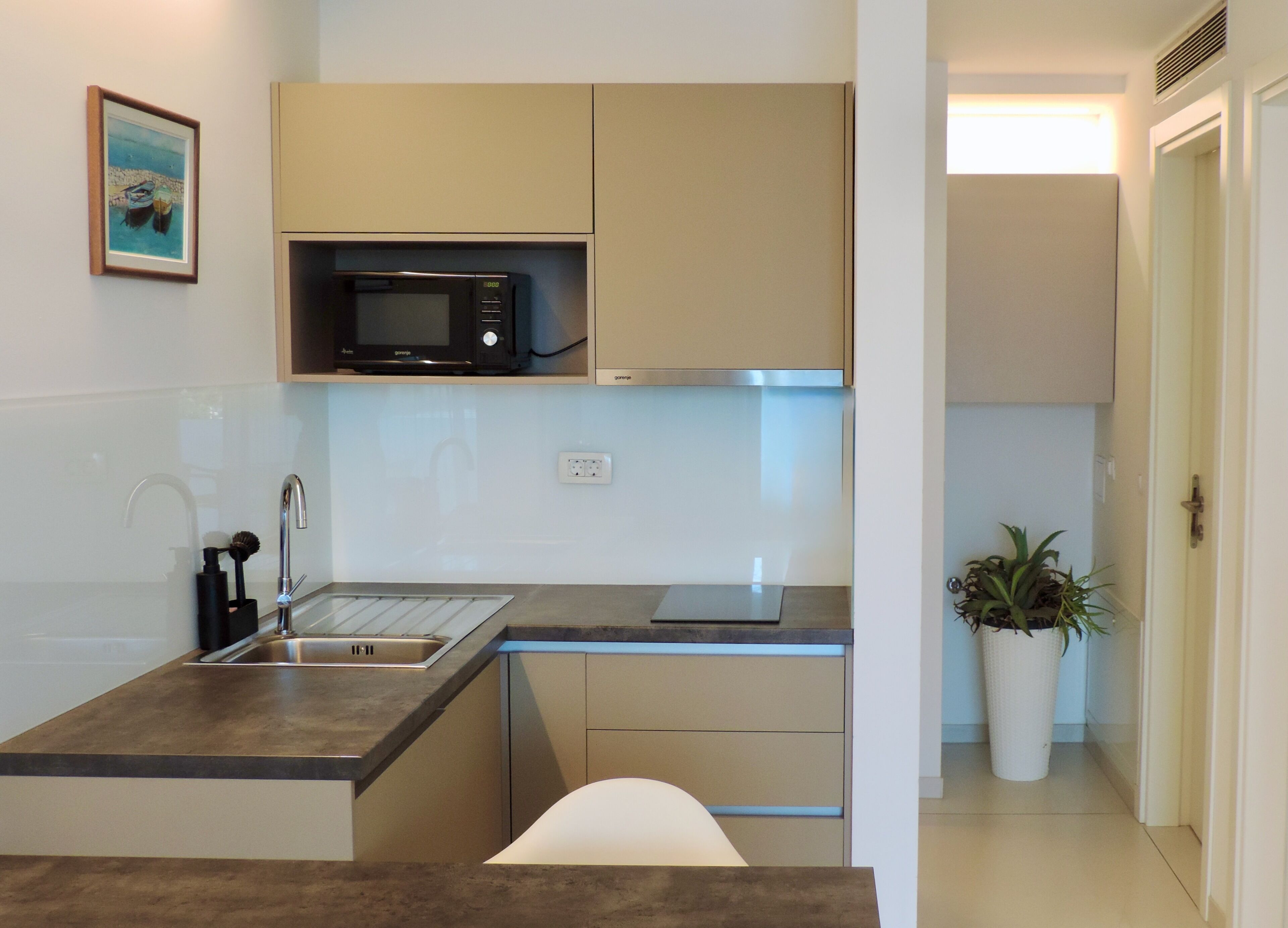 A compact kitchen with a microwave, sink, and a small countertop.