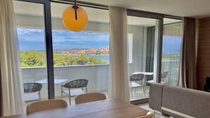 Una sala de estar moderna con comedor, ventanas amplias y vista a la ciudad.