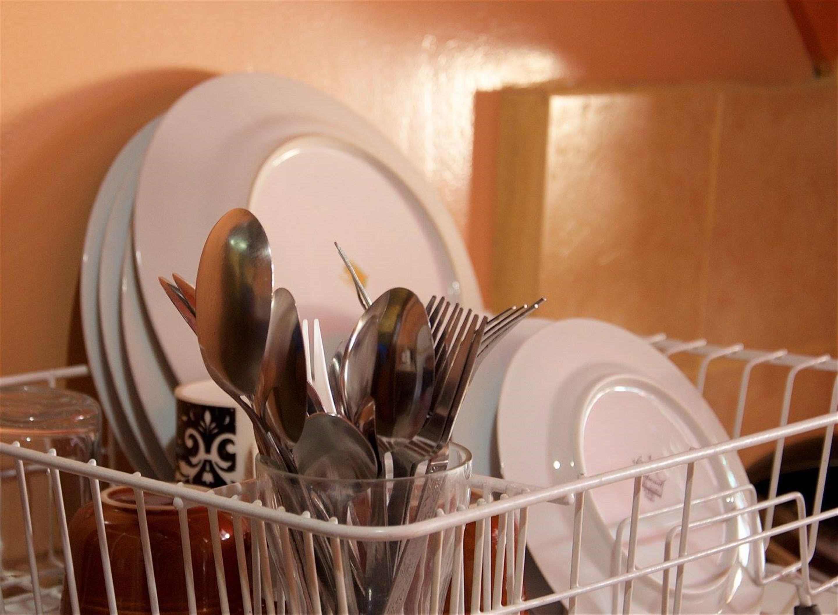 A dish rack with various dishes and utensils.