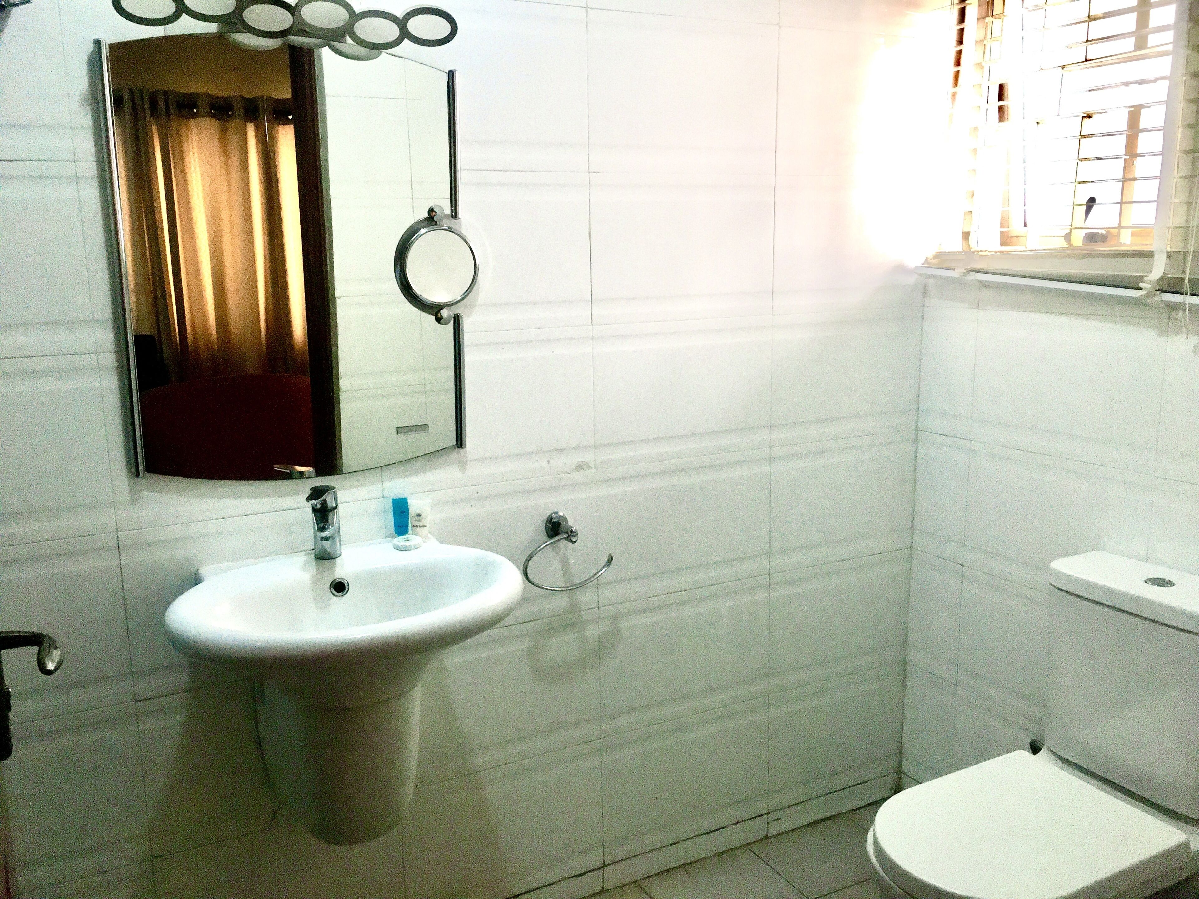 A bathroom with a white sink, a mirror, and a toilet.