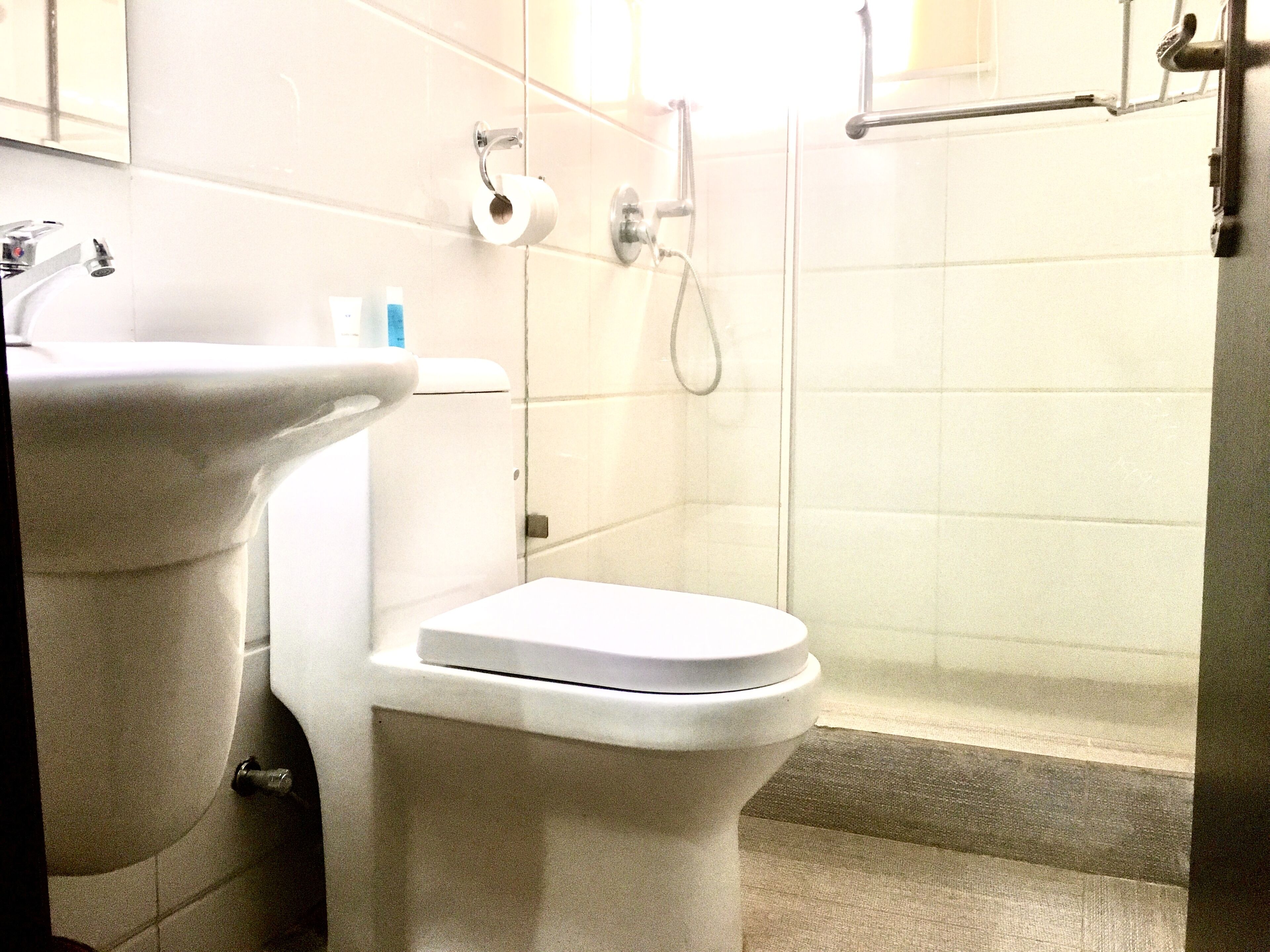 A bathroom with a sink, toilet, and shower.