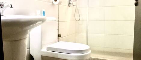 A bathroom with a sink, toilet, and shower.
