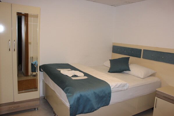 A bedroom with a bed, a nightstand, a wardrobe, and a mirror. - Selale Otel ve Bungalow (Çaykara)