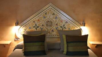 Una cama con almohadas decorativas y un cabecero estampado.