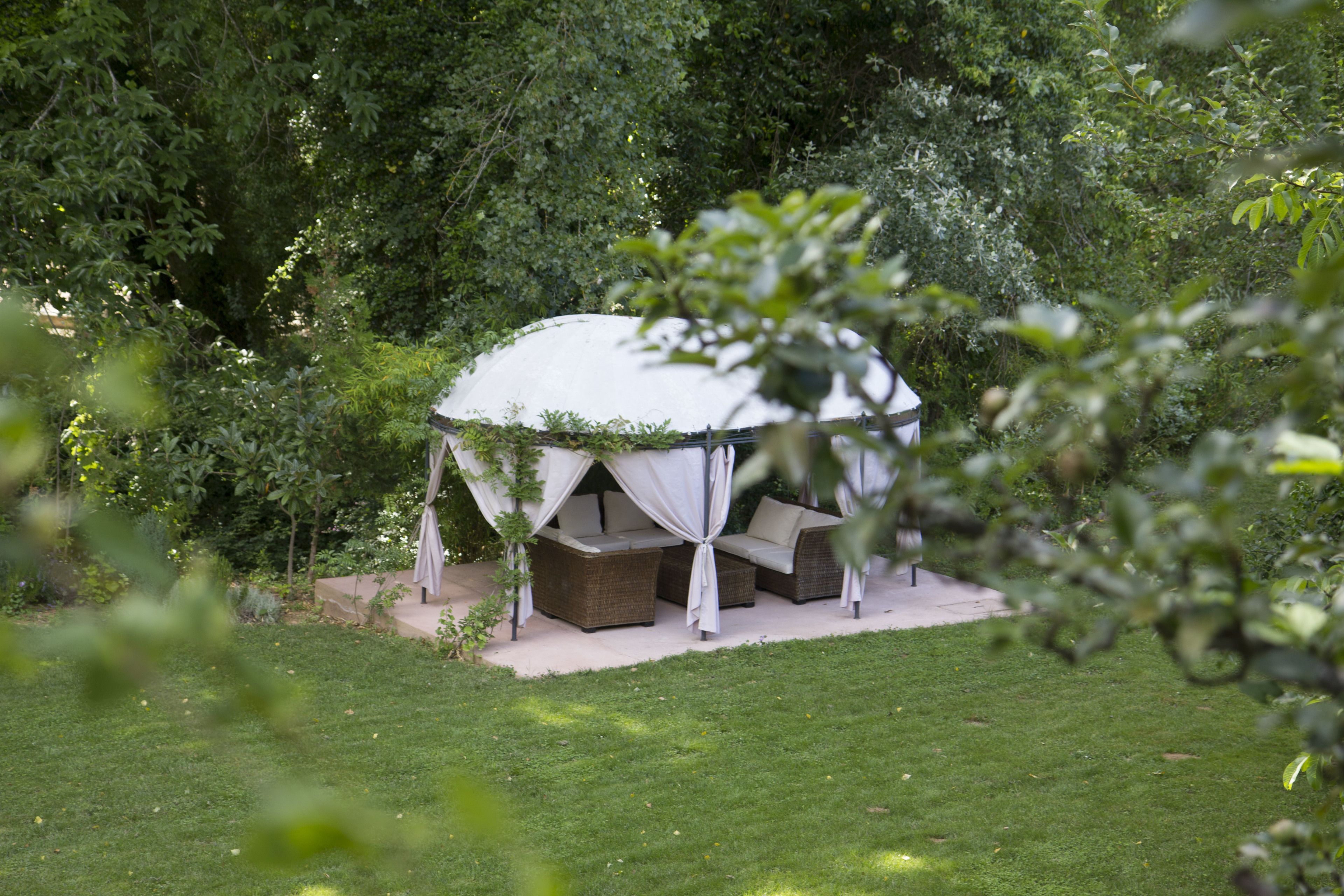 Ein Zeltenbereich im Freien mit Sitzgelegenheiten und einer überdachten Terrasse.