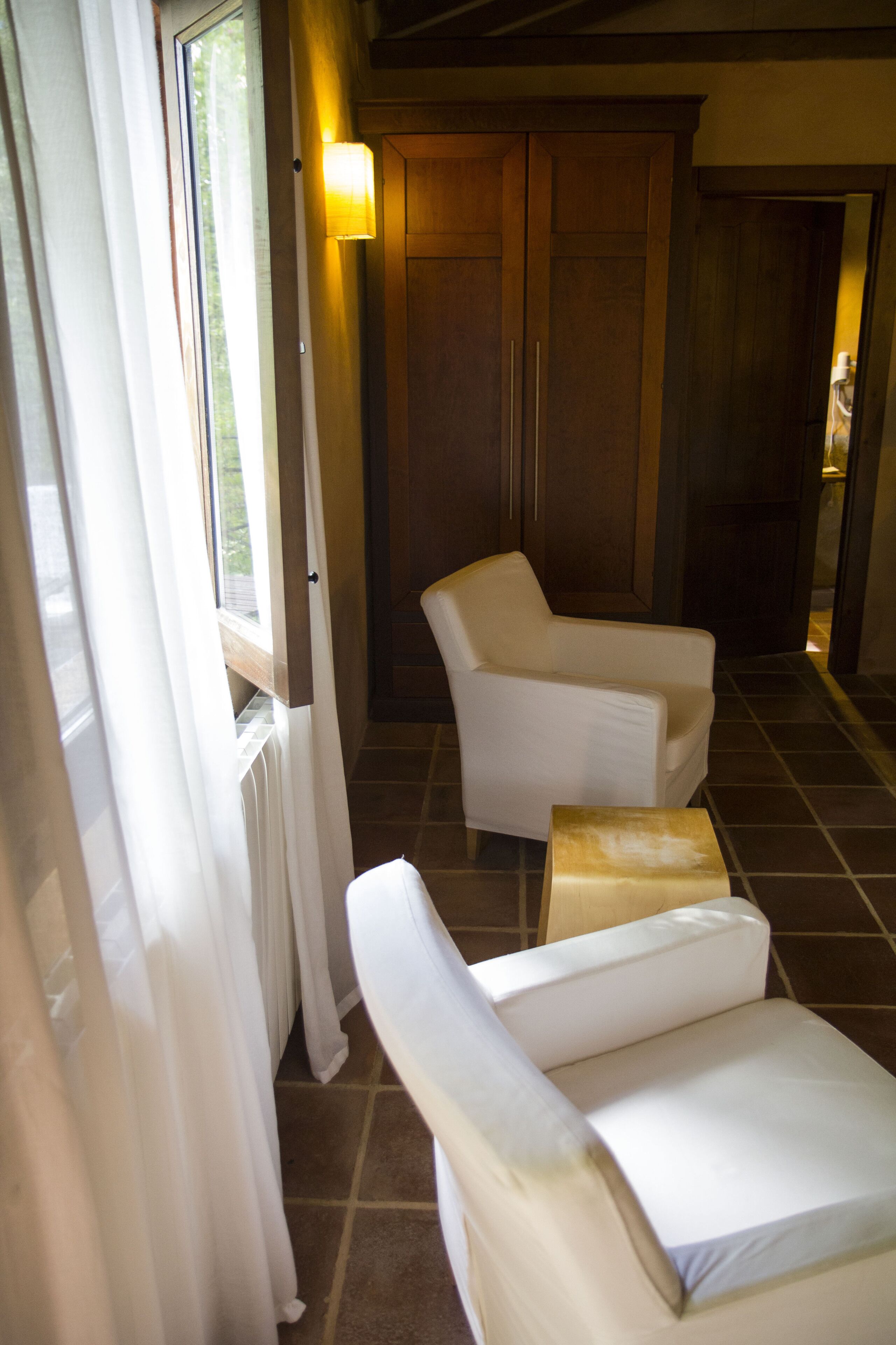 A room with a window, a chair, and a small table.