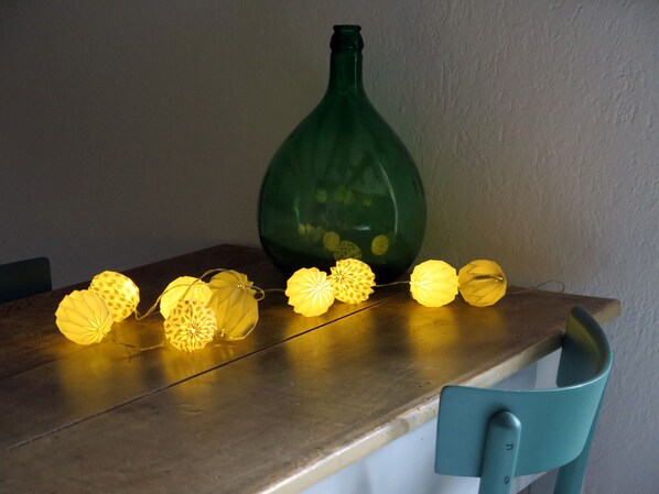 Una mesa con farolillos decorativos y una botella verde.