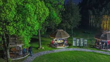 A park with a gazebo, a small hut, and a pathway.
