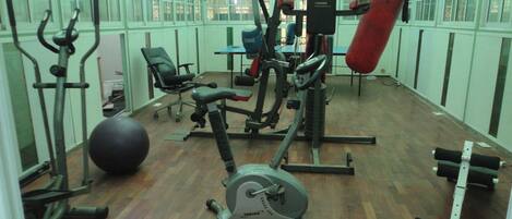 A gym with exercise equipment, a punching bag, and a large exercise ball.