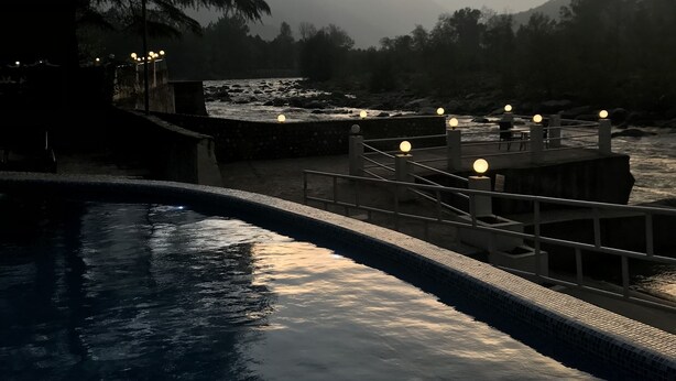 Un espace piscine extérieur paisible, offrant une vue sur les montagnes et un magnifique coucher de soleil.