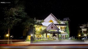 Un bâtiment à deux étages, reconnaissable à son enseigne en forme de pomme, à son entrée protégée par un portail et à sa façade bien éclairée.
