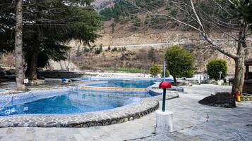 Una piscina al aire libre, sillones reclinables de piscina
