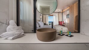 A modern bathroom with a large mirror, a round sink, and neatly folded towels. - Assano Sea Front Luxury (Sithonia)