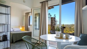 A balcony with a bed, a table with two cups, and a chair. - Les Toits de Santa Giulia (Porto-Vecchio)