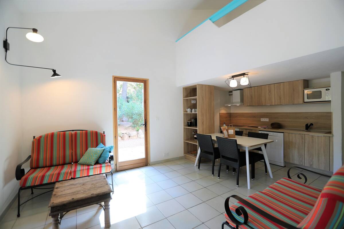 Ein gemütlicher Wohnbereich mit Sofa, Esstisch und Küchenzeile.