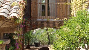 A rustic house with a wooden balcony, stone walls, and a tiled roof. - Les Toits de Santa Giulia (Porto-Vecchio)