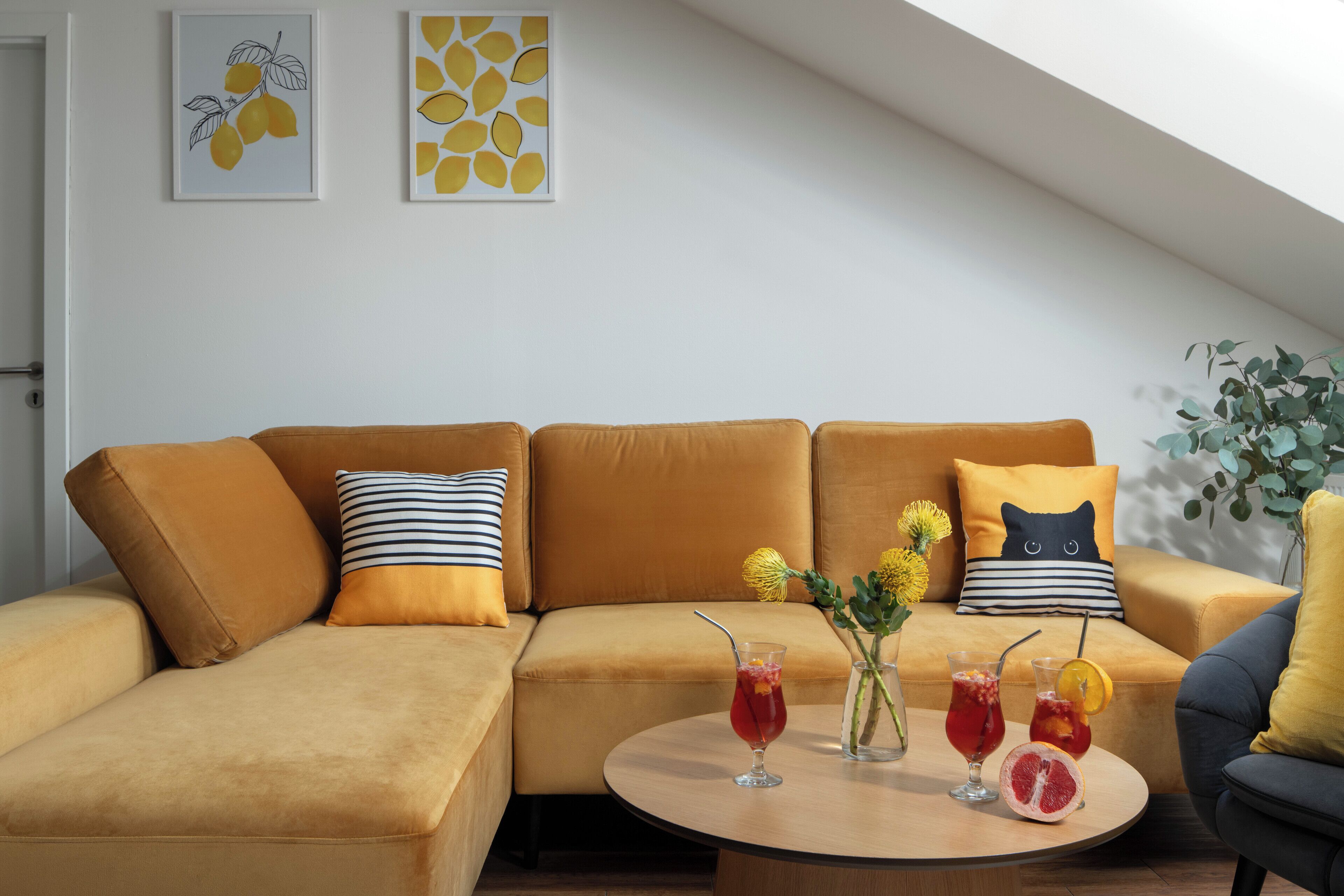 A modern living room with a sofa, a coffee table, and two drinks.