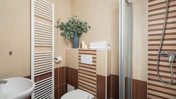 A bathroom with a white sink, toilet, and a shower area.