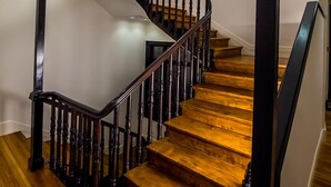 A wooden staircase with black railings and a curved design. - Hotel Boutique Loriente (Ribadeo)