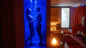 A room with a red carpet, a lit candle, and a projection screen displaying a couple. - Hotel Dusseldorf (Rimini)