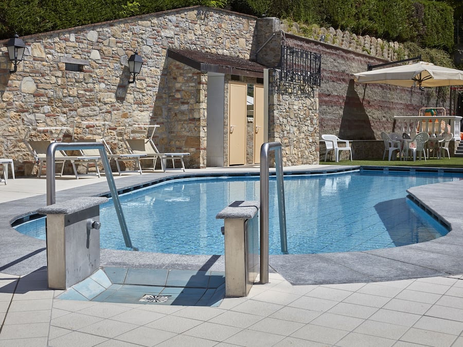 Una piscina al aire libre de temporada, tumbonas