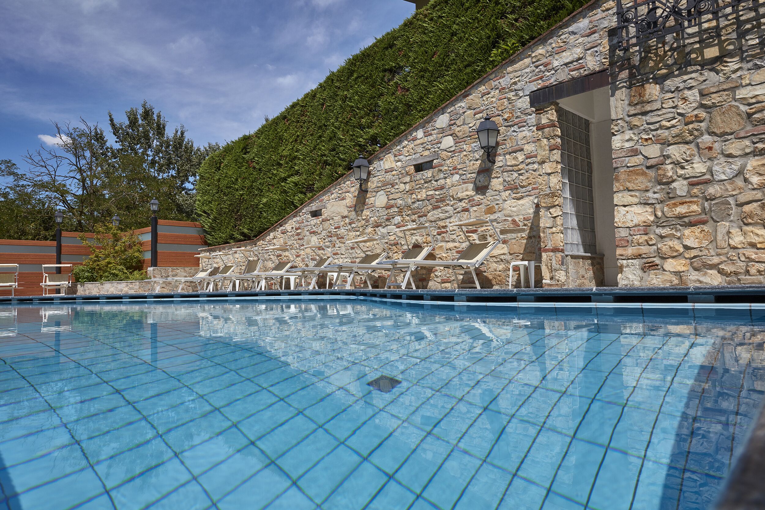Una piscina al aire libre de temporada, sillones reclinables de piscina